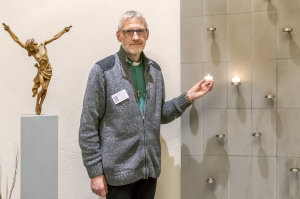 Diakon Jürgen Jeremia Lechelt zündet im Raum der Stille eine Kerze an